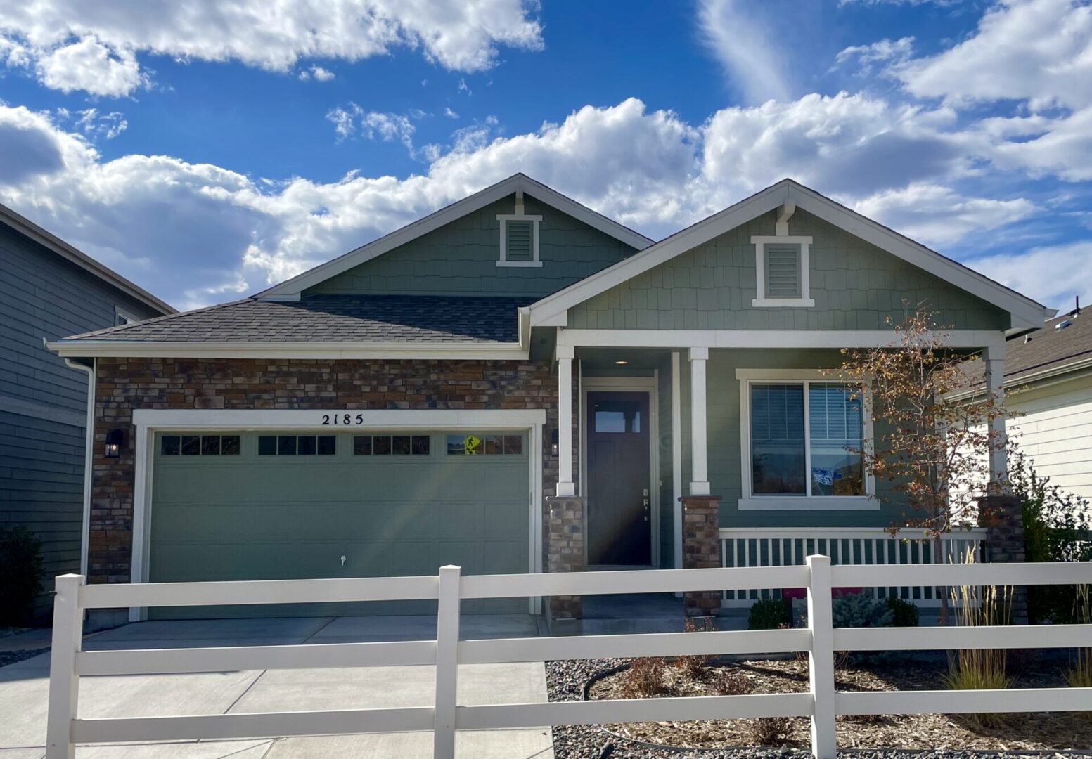 A house with a white fence and blue sky